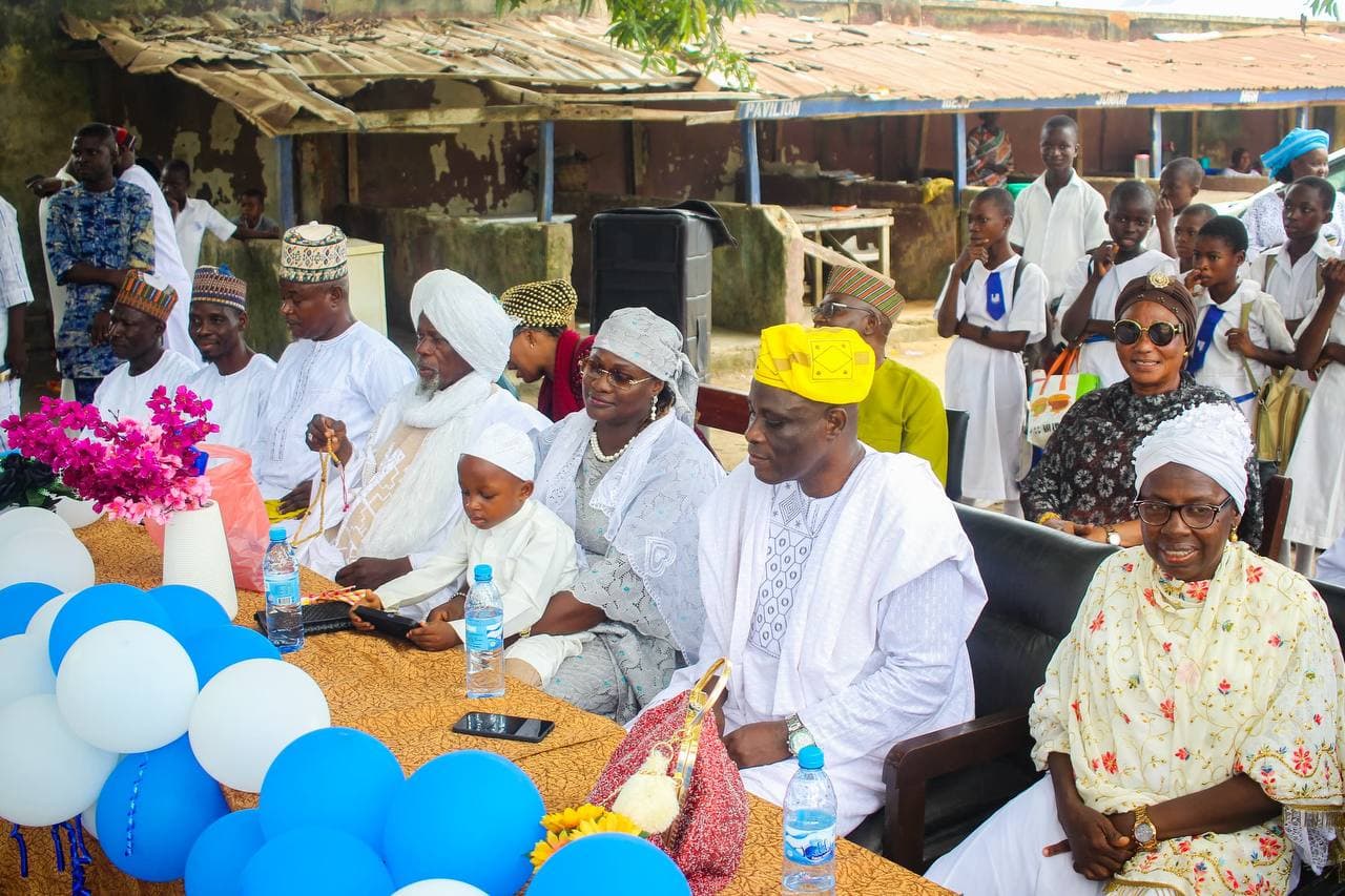 Seated among guests and pupils